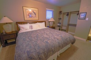Master bedroom with king bed and open closet, ceiling fan.