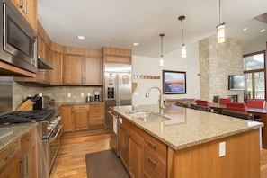 Open kitchen with island and 3 bar stools