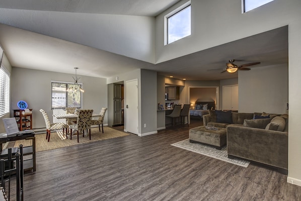 Living Room/Dining Area with vaulted ceilings and an abundance of natural light 