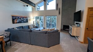 Living room with gas fireplace, dining table, and balcony w/ propane BBQ grill