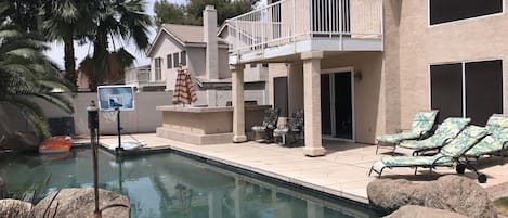 Private back yard, fenced and gated with pool, lounge chairs, and gas grill