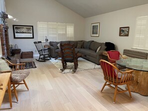 Living room w/ queen sofa bed and wood burning fire place.