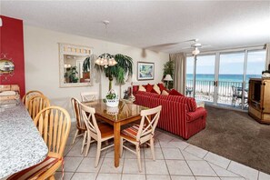 Living room and dining room looking out to balcony and ocean.