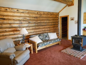 Cozy living room with wood stove. Futon folds out to a full size bed.