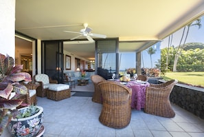 Large lanai has ocean and garden views with comfortable wicker seating.