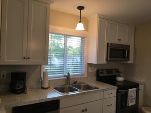 Double sink, dishwasher, Keurig and Regular drip coffee maker. Flat top stove