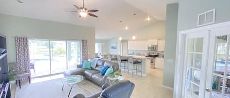 Bright open concept living with 13' ceilings and several pool views. 