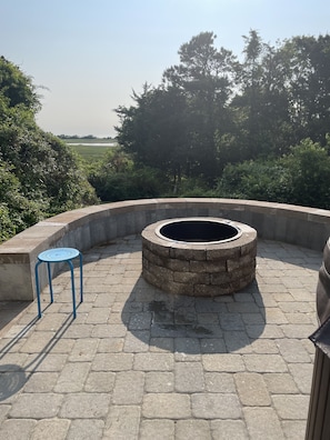 New fire pit on new patio with raised seating in backyard