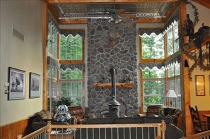 Abundant natural light and wood stove provide a cozy atmosphere.