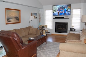 Living area on first floor with 60" HDTV,  game table, gas fireplace. Recliner 