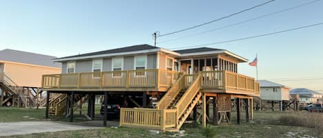 Street view of the house with parking 
for one car under the house.