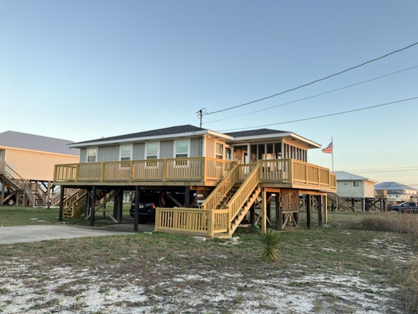 Street view of the house with parking 
for one car under the house.