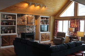 Great room with vaulted ceilings, sectional, 2 recliners, cable TV & fireplace.