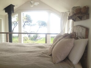 The comfy queen bed with a spectacular view of the water.