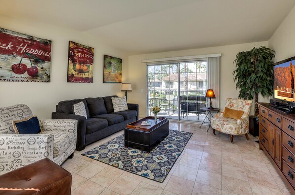 Well appointed living room opens to balcony with view of pool and mountains