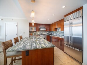 Prepare meals effortlessly in this luxurious kitchen, complete with high-end appliances, granite countertops, and elegant pendant lighting.
