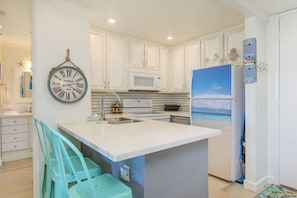 Kitchen with bar seating, fully stocked with all of your cooking needs