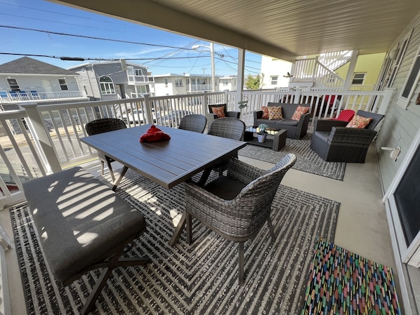 Covered porch with dining table for 6+ people and comfortable lounge area