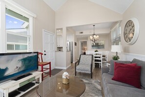Open floor plan includes living, dining and kitchen areas. View from front French doors that lead out to small balcony with seating
                