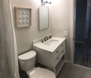 Clean, full bathroom with brand new vanity and tile.