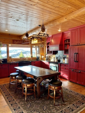 Custom red kitchen with antique woodworkers table 