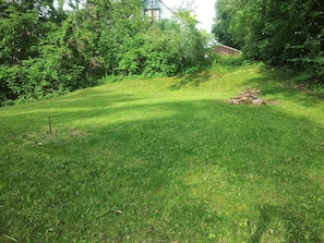 Back yard with fire pit and area for bag toss and other games.