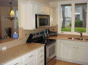 Kitchen looks out to side yard & overlooks Living Room & Dining area.