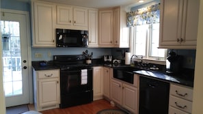 Fully equipped kitchen with dishes, glasses, cookware and staples.