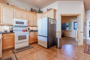 State-of-the-art refrigerator in kitchen and access to main floor bedroom