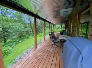 Deck with gas grill, dining table and fire pit overlooks the trail to beach.