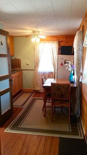 Kitchen / dining area.  Table, 2 chairs, fridge with freezer, microwave