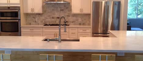 Kitchen with an L-shaped bar and eight bar stools