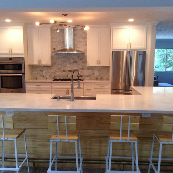 Kitchen with an L-shaped bar and eight bar stools