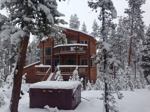 view of the back of home with hot tub 