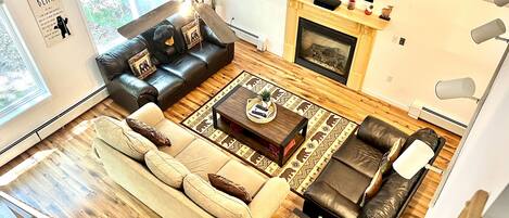 Family room with cathedral ceilings, gas fireplace and 55 inch smart tv.