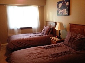 Two twin beds in 2nd bedroom. Ceiling fan and television.