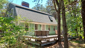 Gambrel with front deck on a wooded lot