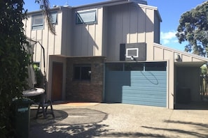 Outside of house, plenty of outdoor parking, a trampoline and basketballhoop.