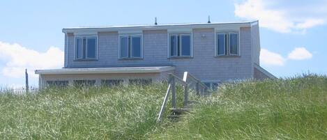 Beach House with sun reflected in the beach grass in July