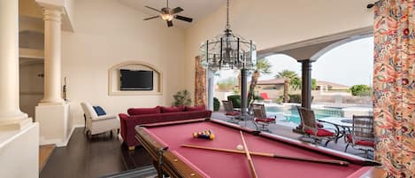 Entertainment Room with Glass wall open to outdoor dining area and pool.