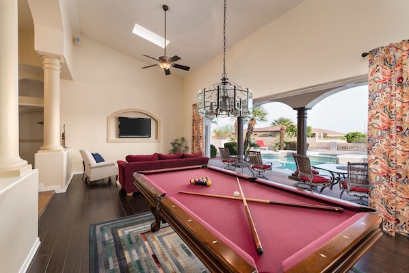 Entertainment Room with Glass wall open to outdoor dining area and pool.