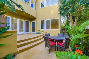 Tropical landscaping surrounds private side yard dining