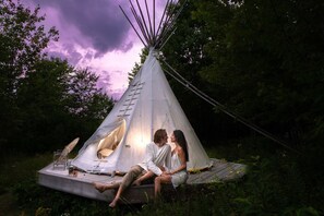 Night time view of the onsite tipi and wildlife observation deck. 