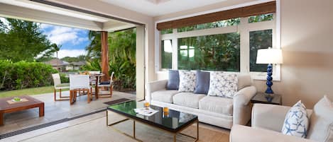 Open Concept Living Room opens to Lanai and lush gardens