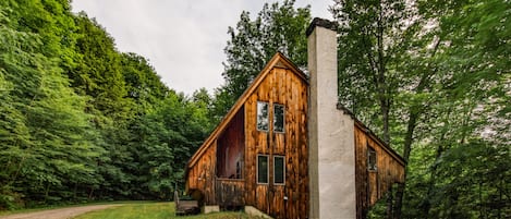 View of the house from the driveway.  On over an acre, surrounded by trees.