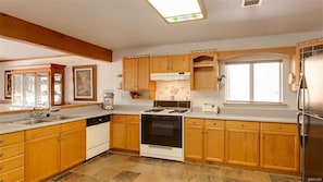 The kitchen has a sink, oven and stove, refrigerator and microwave. 