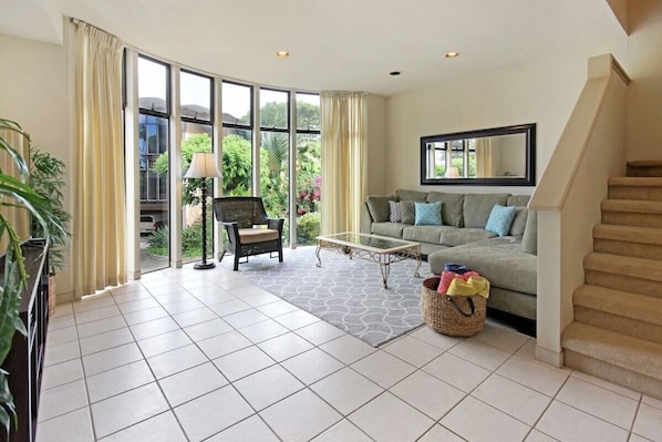 Floor to ceiling windows over looking the  tropical grounds of the unit.