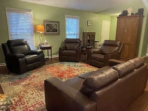 Living room features leather furniture and seating for seven