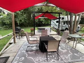Outdoor living space includes plenty of space, a firepit, hot tub, and grill.