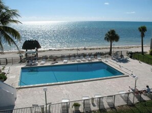 Overview of the pool and the beach and ocean beyond it.
